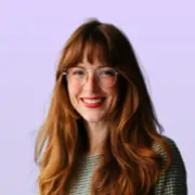 Smiling woman with red hair and glasses
