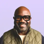 Smiling man with glasses and green vest