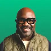 Smiling bald man with glasses on green background
