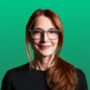 Smiling red-haired woman with glasses on green background